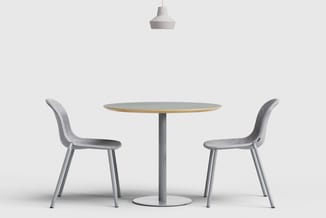 Ronde tafel met grijs blad en gouden rand, twee grijze stoelen met gebogen rugleuning, hangende witte pendant lamp.
