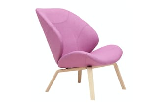 Roze fauteuil met organische vormen, houten poten, zijkant zicht tegen witte achtergrond.