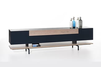 Moderne TV-meubel met zwarte kastdeuren, licht houten blad en onderplank. Sierflessen op het bovenblad, boeken op de onderste