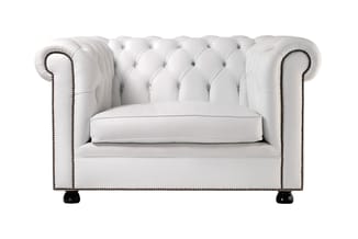 Witte Chesterfield-fauteuil met gestoffeerde knofook en zitdeel, voorzien van bronzen studs en zwarte voetjes.