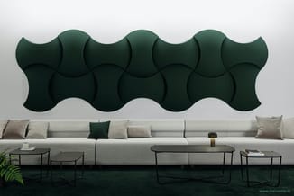 Grijze loungeset met groene wiebel-akoestiekpanelen aan wand, zwarte metalen tafels, plant op voorgrond.