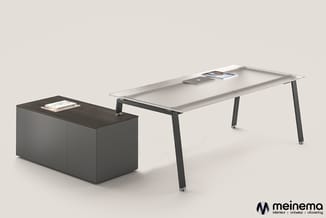 Kantoorset met grijs bureau met zwarte poten en donkergrijs kastblok met blad, op neutrale achtergrond.