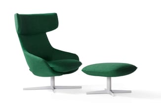 Groene fauteuil met hoge gebogen rugleuning en bijpassende voetenbankje, beide op wit metalen kruisvoet.