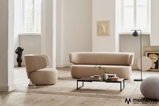 Moderne loungeruimte met beige gestoffeerde sofa en fauteuil, zwart metalen salontafel, staande lamp en ronde poef op lichte