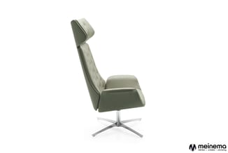 Moderne loungestoel in grijs-groen met hoge rugsteun, ergonomische zitting en zilveren voetkruis, zijprofiel tegen witte acht