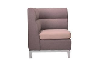 Grijze hoekfauteuil met roze zitting, stofbekleding en houten poten, zijkant rechthoekig ontwerp.
