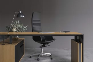 Moderne kantoorkamer met houtkleurig bureau, zwarte bureaustoel, zwarte bureaulamp, potplant en notitieblok tegen grijze wand