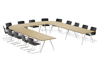 U-vormige vergadertafel met licht houtfineer blad en wit frame, omgeven door zwarte kantinestoelen op sledeframe.