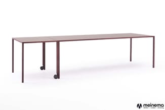 Lange vergadertafel met donkerrode houten frame en twee verrijdbare middensteunpoten, geschikt voor grote groepen.