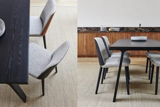 Grijze stoelen met zwart houten frame rond zwarte tafel in kantoor met houten kasten en beige tapijt.