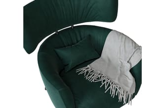 Groene fauteuil met witte armleuningen, donkergroene kussen en lichtgrijze plaid met franjes.