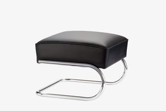 Zwarte loungestoel met chromen cantileverbuis, rechthoekig zitvlak, minimalistische vorm.