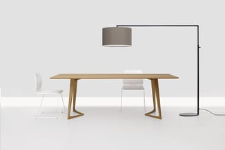 Houten vergadertafel met witte stoelen, hanglamp en staande lamp in minimalistische kantoorinrichting.
