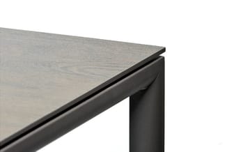 Hoekdetail vergadertafel met grijze houten tafelblad en zwart metalen frame.