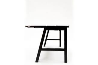 Zwarte houten bartafel met schuine poten en footrest, gezien vanaf de zijkant.