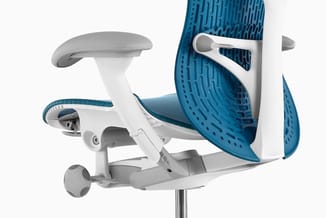 Ergonomische bureaust met wit frame, blauw zitmeer netweefsel, verstelbare armleuningen en voetsteun tegen witte achtergrond.
