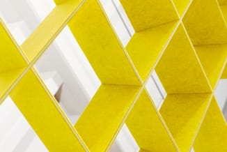3D-patroon van geel en wit geometrische tegels met diamantvormige reliëfs en grijze voegen.