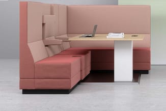 Roze modulair kantoormeubelsysteem met zitbanken, hoge achterwand en houten werkblad met laptop en boeken.