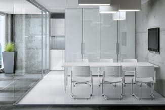 Moderne vergaderruimte met witte tafel, drie witte kantelstoelen, glazen wanden, betonlook wandbekleding en hangende led-verl