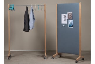 Houten garderoberek met chromen stang en blauwe hangers, naast blauwe akoestische paneel met houten frame en foto's.