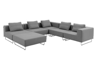 Grijze modulaire loungeset met chaise longue, zitgedeelten en metalen poten, aangepast rond centrale tafel.