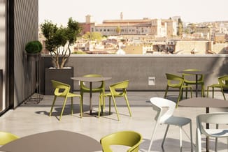Terras met gele stoelen, grijze tafels, potplanten en uitzicht op historische stadhuizen en gebouwen.