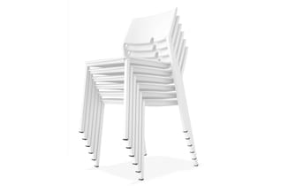 Stapelbare witte kunststof stoelen met metalen poten, in verschillende hoeken gestapeld tegen elkaar.