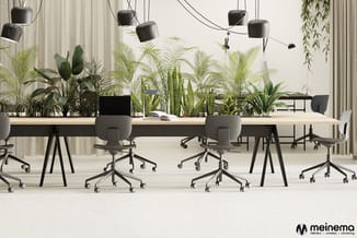 Modern kantoor met houten bureaus, grijze ergonomische bureaustoel en zwarte hangende lampen. Achtergrond beplant met diverse