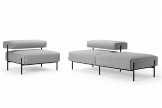 Grijze modulaire zitmeubels met zwart metalen frame: loungefauteuil en daybed/chaise longue met afneembare rugkussens.