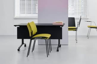 Moderne kantoorruimte met zwart bureau met wieltjes, gele gestoffeerde draaistoelen met zwart frame, stapelstoelen en bureaul