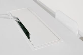 Witte bureau-organizer met rechthoekige vorm, voorzien van vakken voor papier en een groen potlood, tegen witte achtergrond.