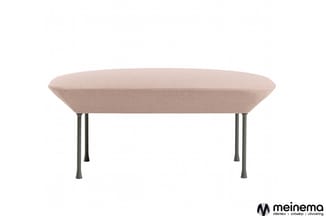 Beige gepolsterde ovale zitbank met grijs metalen poten op witte achtergrond.