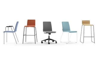 Vijf stoelen in verschillende uitvoeringen: blauwe stoel met armsteunen, bruine barstoel, grijze bureaustoel op wielen, turqu