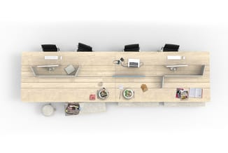 Houten werkblad van bovenaf met vier zwarte bureaustoel, laptops, monitoren, eetservies en kantoorbenodigdheden.