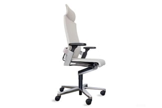 Witte ergonomische bureaustoel met zwarte armleuningen en voetsteun, op wieltjes met grijs metalen basis.