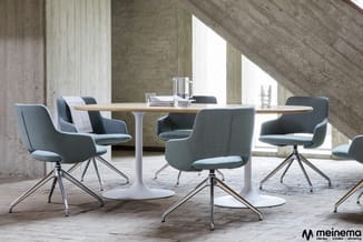 Moderne vergadertafel met wit voetwerk en houten blad, omgeven door grijze draaistoelen met metalen onderstel in industriële