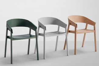 Drie stoelen in verschillende kleuren: groen, grijs en naturel hout, met gebogen rugleuningen en armsteunen, tegen neutrale a