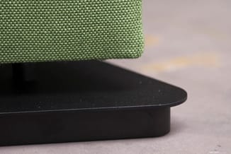 Groene akoestische paneel op zwart metalen voetje, detail van materiaal en constructie.