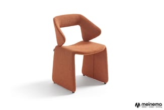 Terracotta stoel met gebogen rugleuning en gestoffeerde zitting, minimalistische vormgeving, staand tegen witte achtergrond.