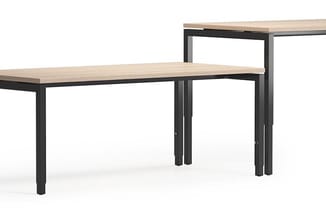 L-vormig bureau met licht houten blad en zwart metalen onderstel, modulair ontwerp.