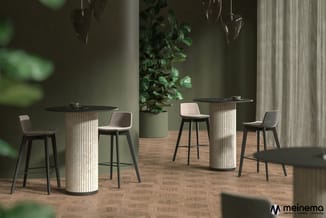 Moderne kantoorruimte met twee ronde tafels met geribbelde zuilen in licht hout, zwarte tafelbladen en beige stoelen met zwar