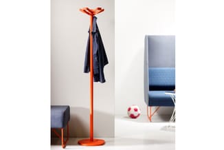 Oranje garderobe standaard met zwart-blauwe kleding, naast grijze zitbank en voetballetje in kantooromgeving.