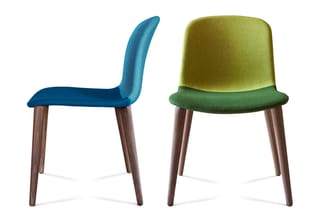 Twee moderne stoelen met houten poten: links een blauwe stoel met gebogen rugleuning, rechts een groen-gele stoel met rechte