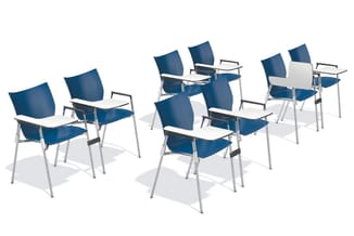 Zes blauwe stoelen met wit werkblad op aluminium frame, gerangschikt in twee groepen in een lege ruimte.