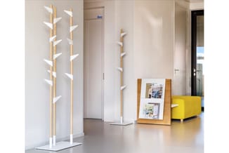 Houten display standaards met witte bladeren en houten magazine rek in moderne kantoorruimte met gele zetel.