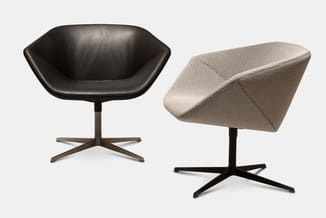 Twee moderne draaifauteuils: links zwart leren model op bruin kruis onderstel, rechts beige gestoffeerde versie op zwart krui