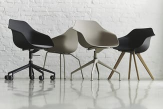 Vier moderne stoelen in zwart, wit en beige met kunststof zitting en verschillende poten (wielen, metaal, hout) tegen witte b