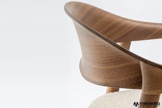 Houten stoel met gebogen rugleuning en zitting bekleed met beige stof, getoond in detail tegen witte achtergrond.