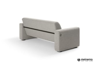 Grijze stofbank met uitklapbare zitting, zwart metalen frame, gezien vanaf zijkant tegen witte achtergrond.