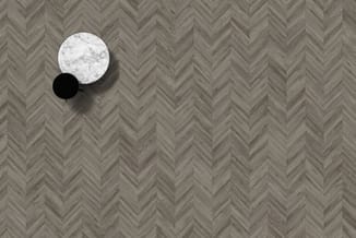 Rond salontafel met marmeren blad en zwart onderstel op herringbone houten vloer.